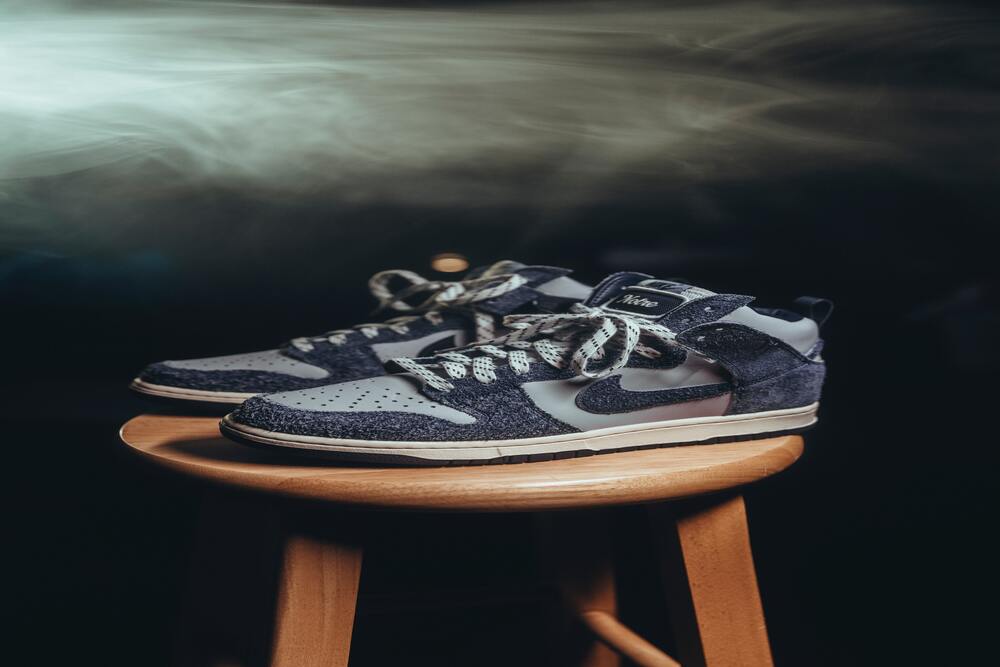 A pair of Blue Nike Dunks lying on a stool.
