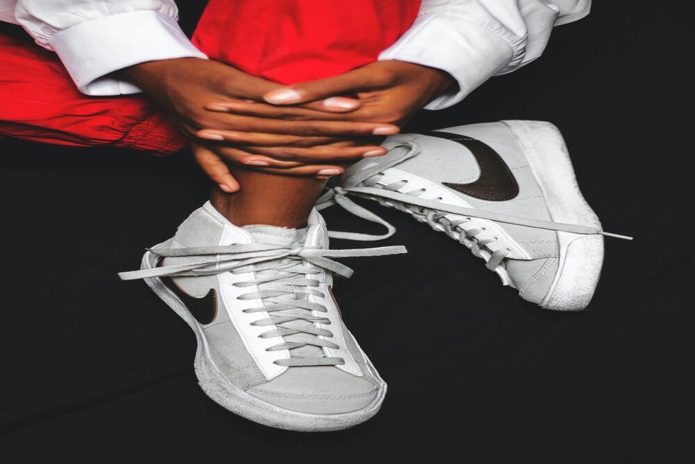 A pair of worn Nike Dunks in cross-legged fashion.
